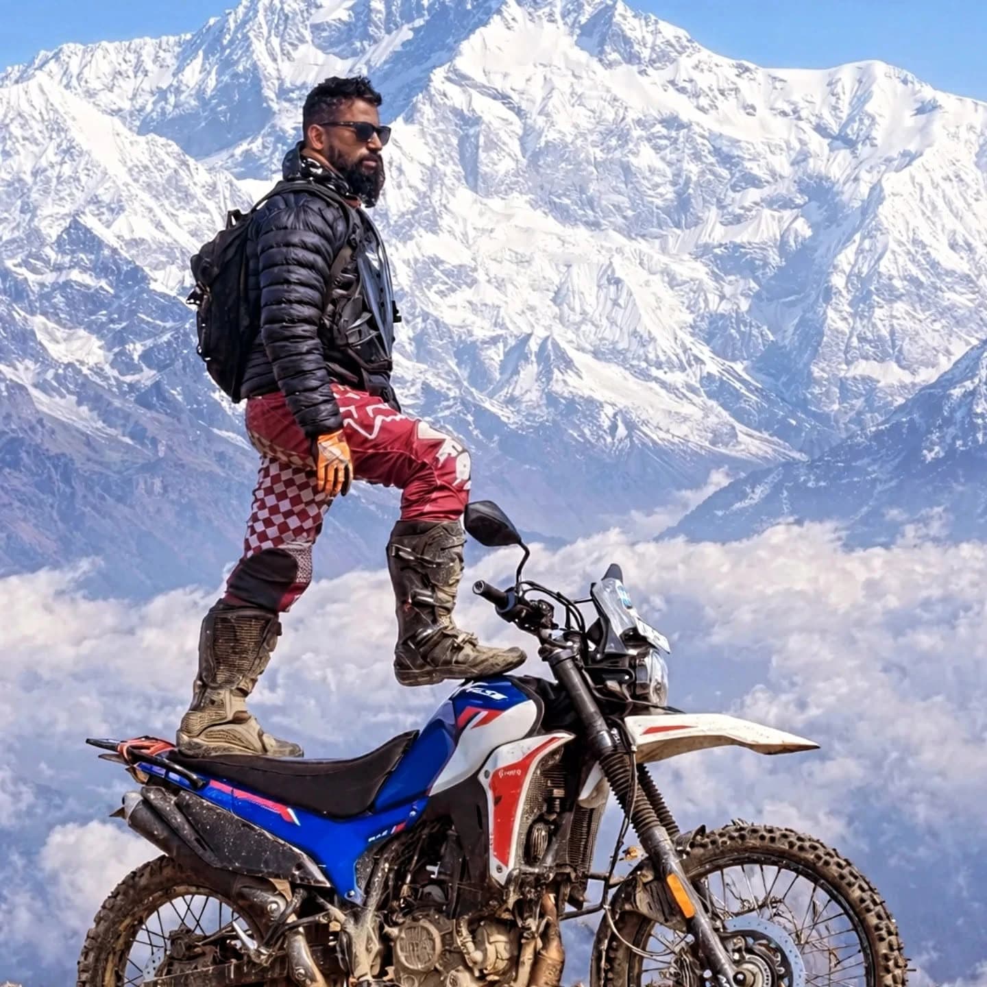Prasanta Barik standing with his adventure motorcycle in the Himalayas