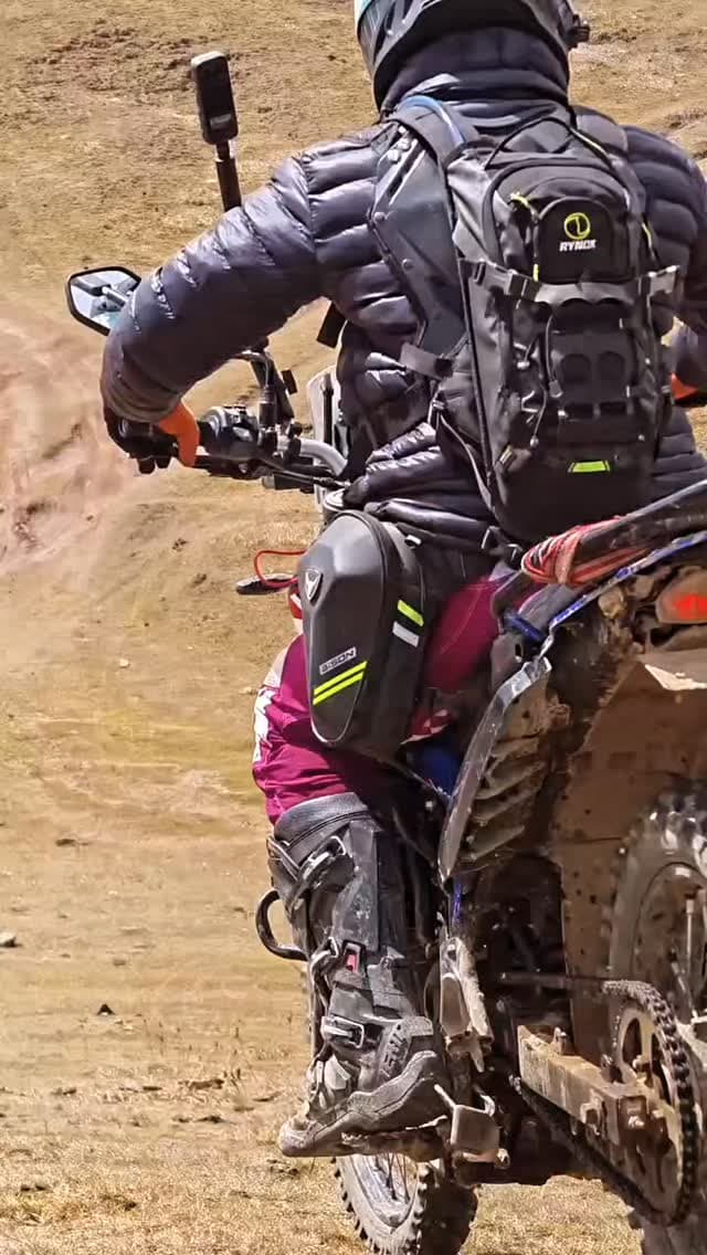 Barik Da riding an adventure motorcycle up a mountain trail